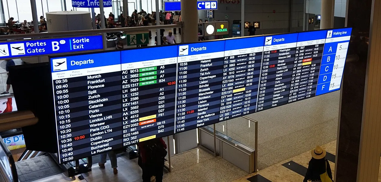 Grand tableau des départs affichant des vols dans un aéroport